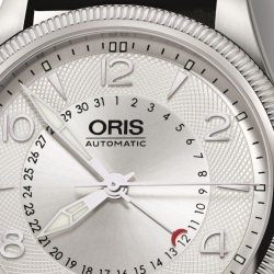 В обновлённых часах хорошо заметны фирменные признаки часов марки «Oris», это – стрелочный указатель даты «Pointer Calendar», а также большая заводная головка «Big Crown».